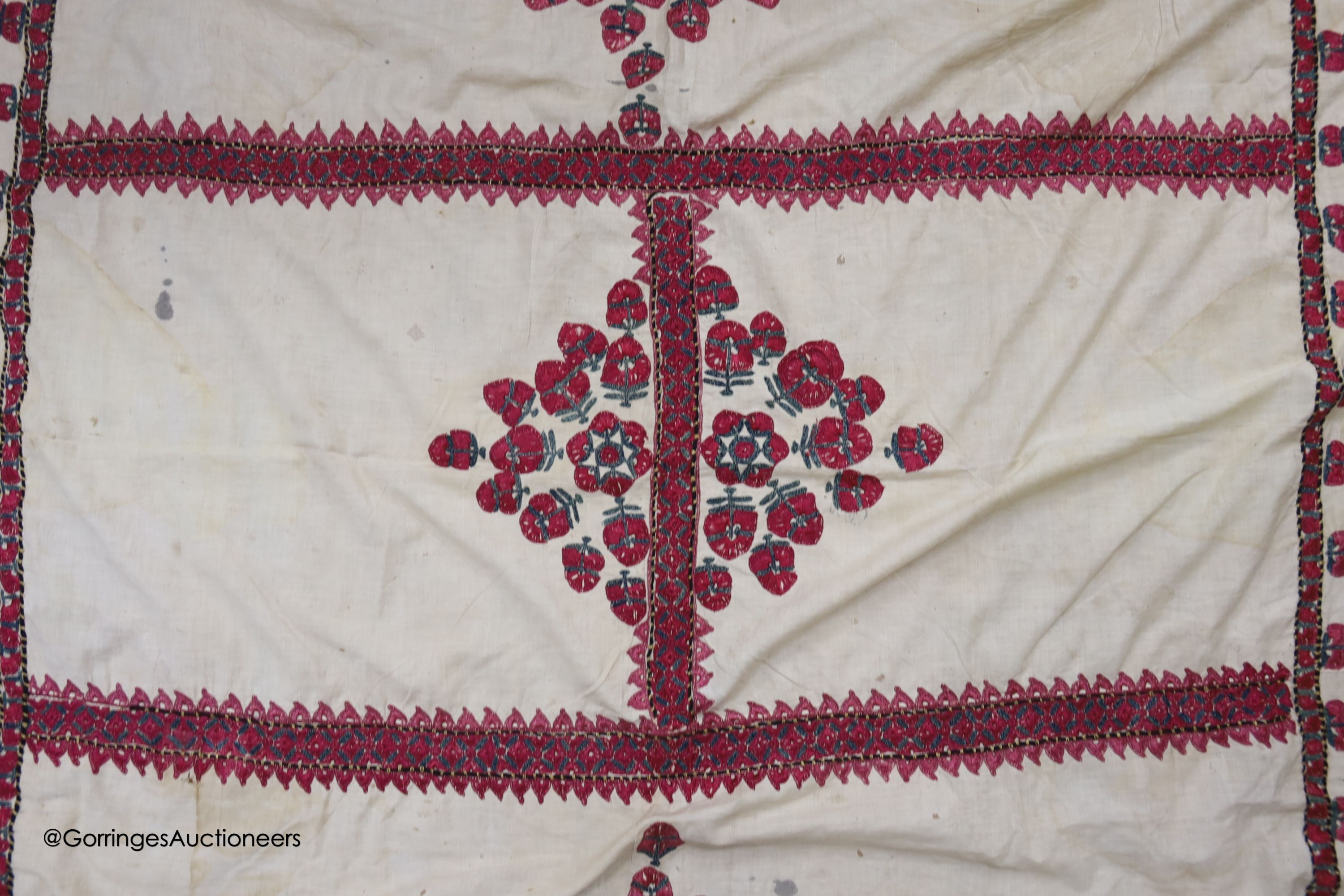 A silk embroidered Suzani, embroidered with cherry red flower heads with green stems and leaves in fine silk, width 134cm length 220cm